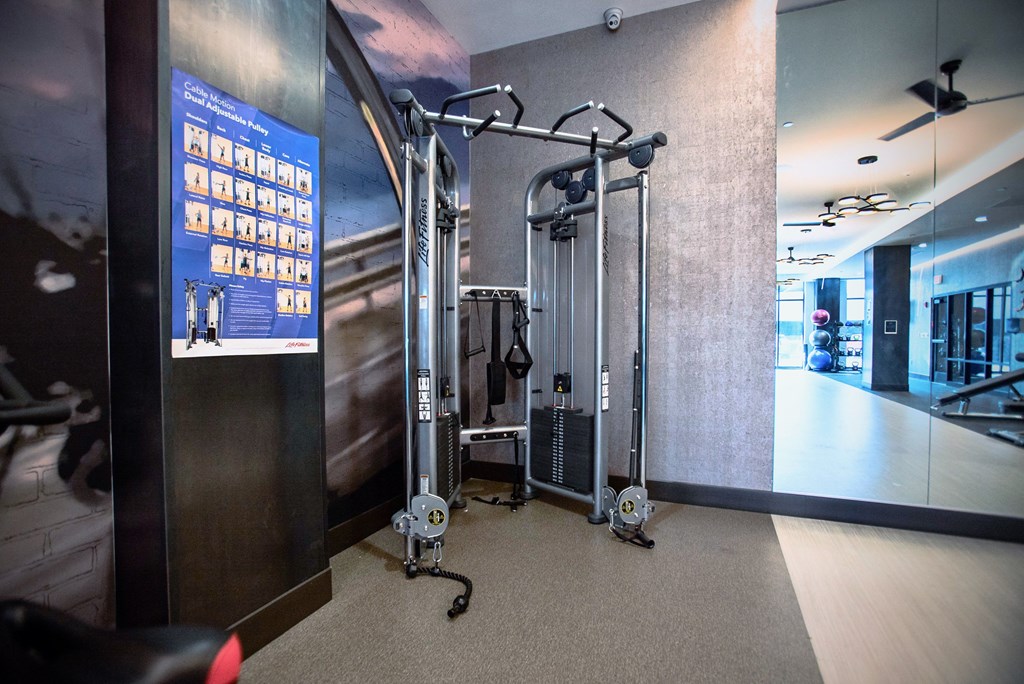 a fitness room with weights and machines in the corner