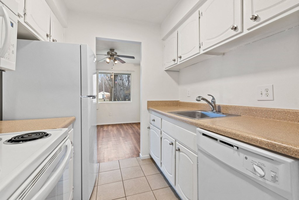 a kitchen with white appliances and a sink and a refrigerator
