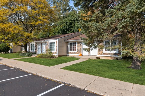 a small house with a sidewalk in front of it