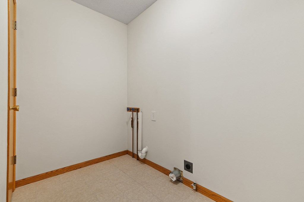 an empty room with white walls and wood trim