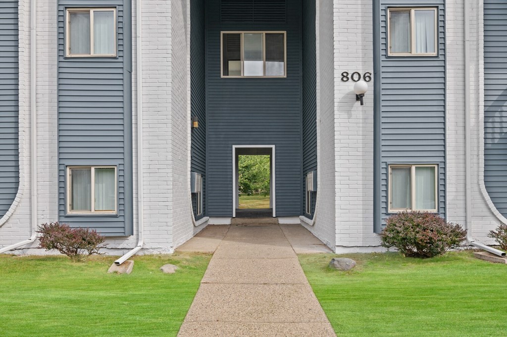 the front of a building with a walkway and a door