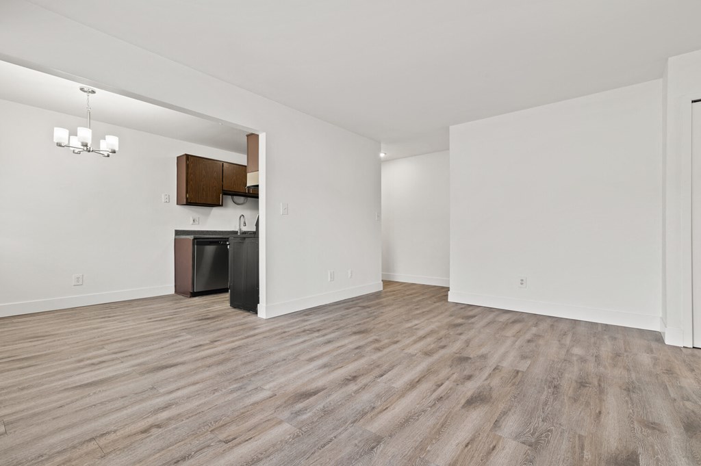 an empty living room with white walls and wood flooring