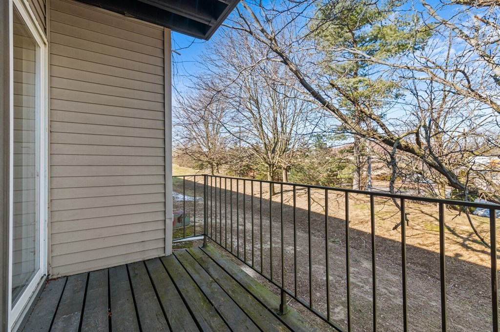 the view from the deck of a home overlooking a yard and trees