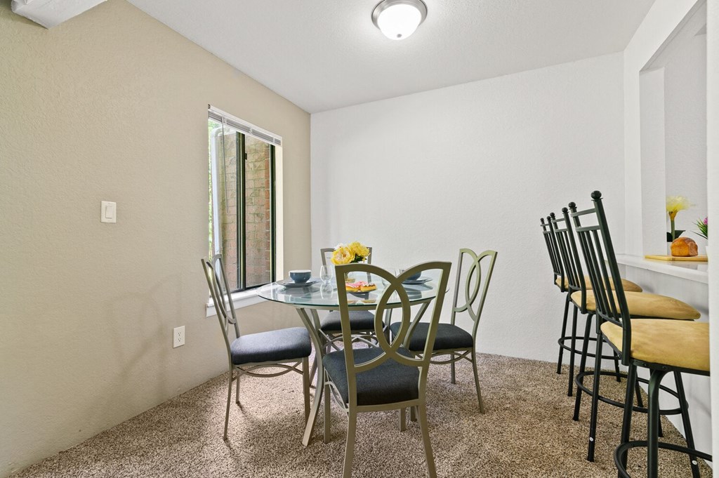 a dining room with a table and chairs and a window