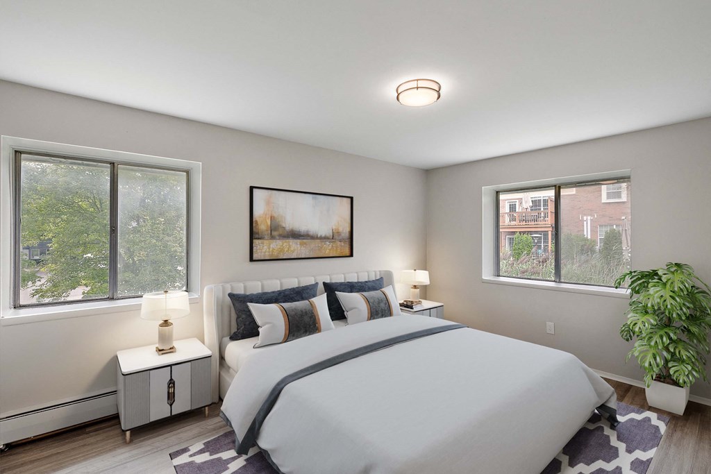 a bedroom with a bed and two windows