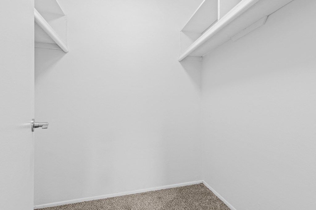 a small room with white walls and white shelves