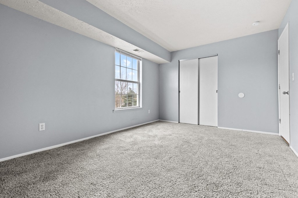an empty room with a window and a door
