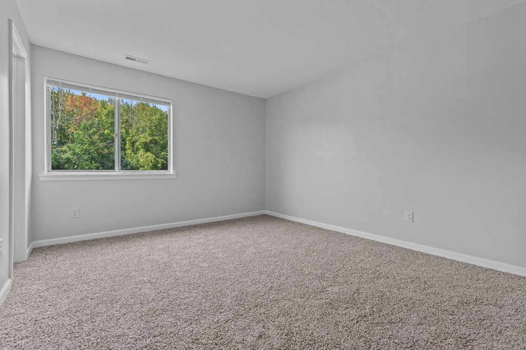 an empty room with carpet and a window