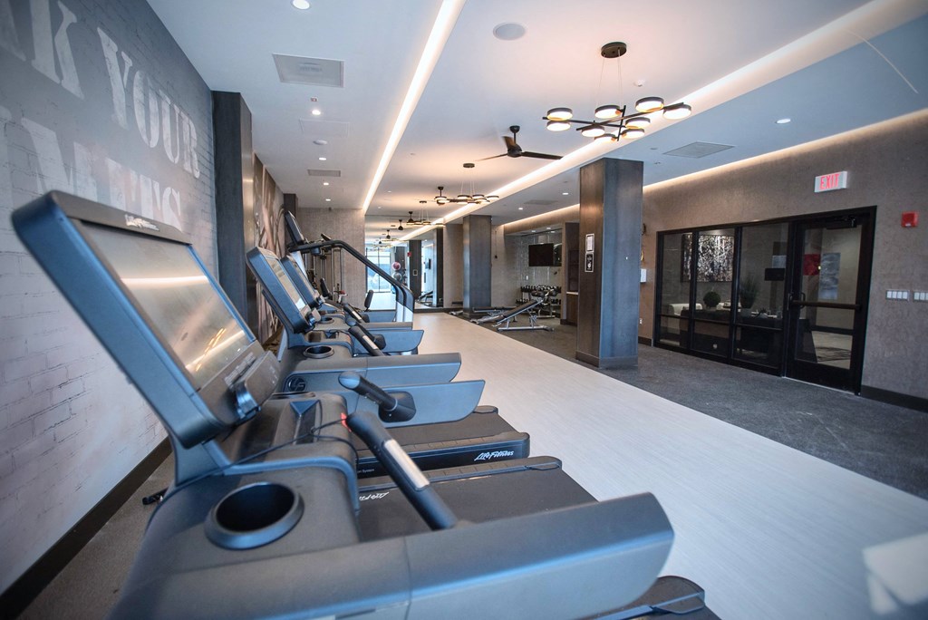 a gym with treadmills in the lobby of a building