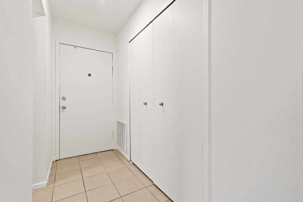 a bedroom with two closets and a tiled floor