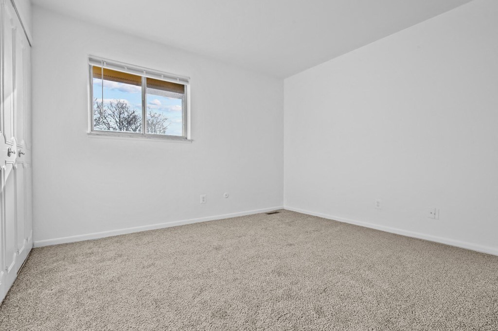 an empty room with carpet and a window