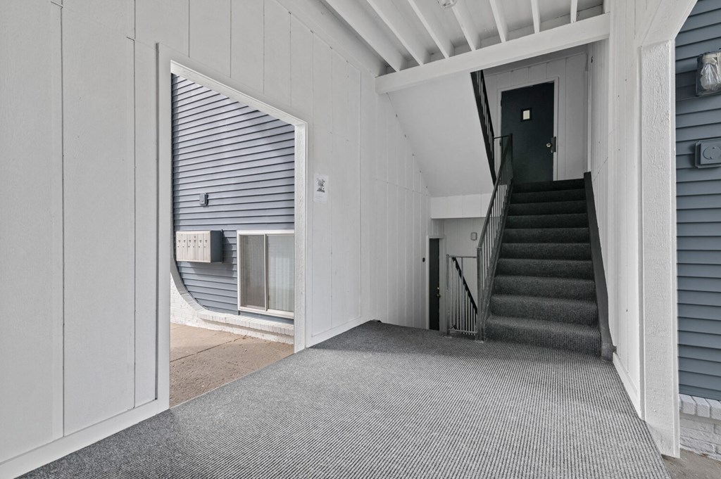 the entrance to a white house with a staircase and a door