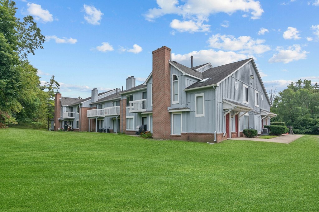 a large green lawn in front of an apartment complex