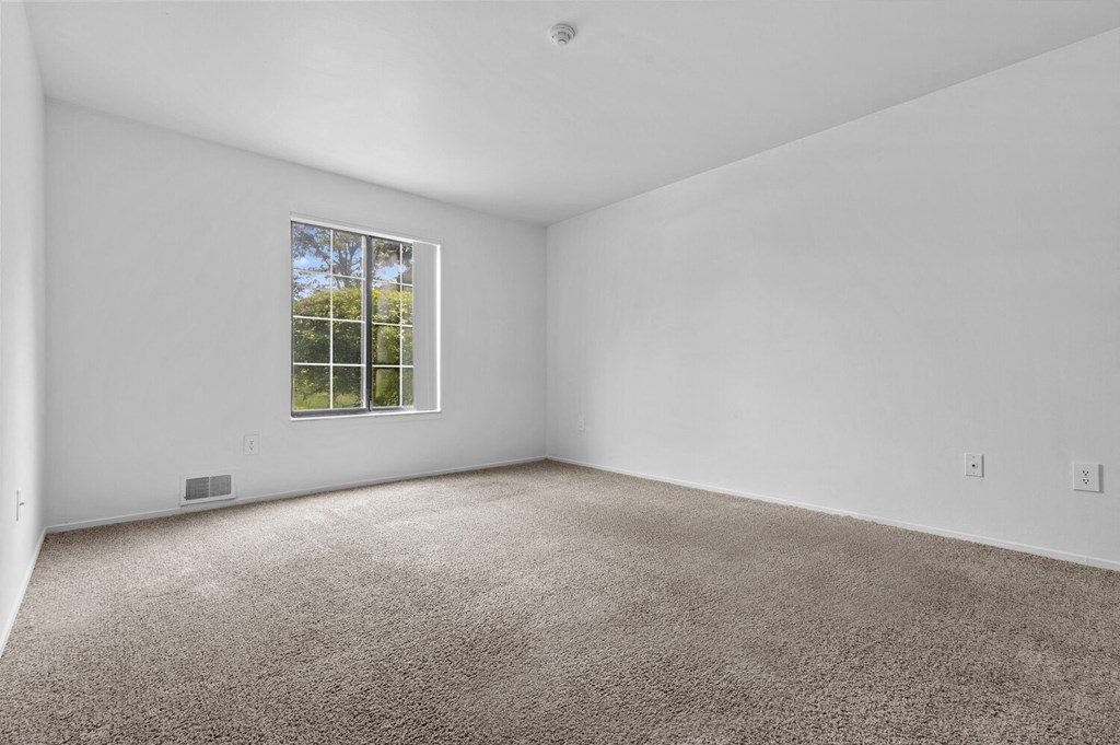 a bedroom with white walls and carpet