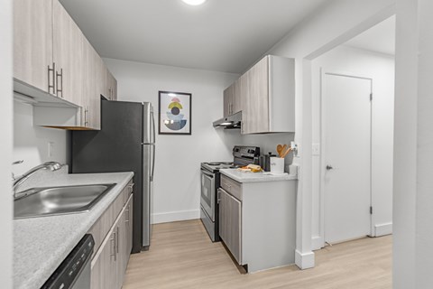 A kitchen with black appliances and white cabinets.
