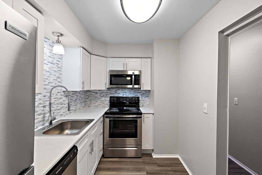 a kitchen with white cabinets and stainless steel appliances