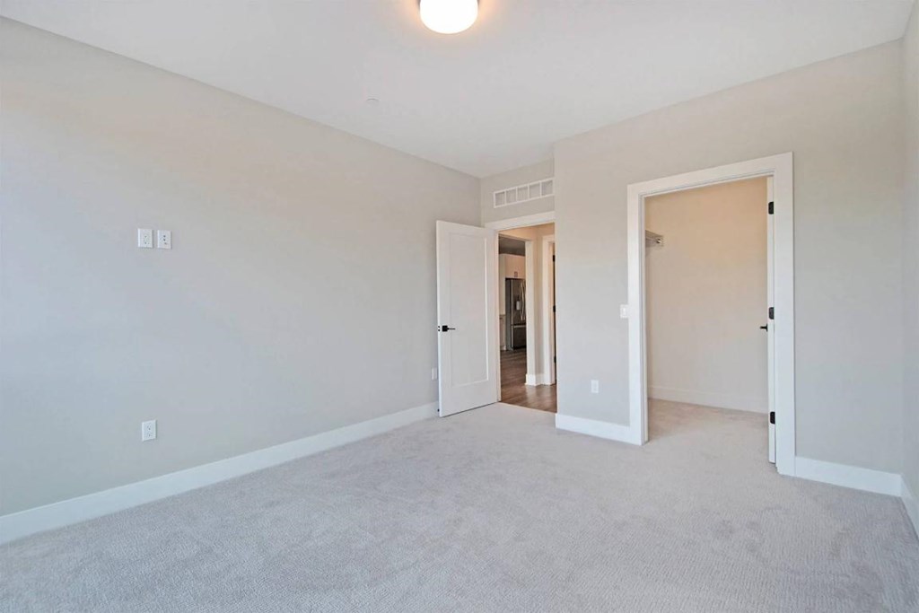 A spacious room with carpeted floor and white walls.