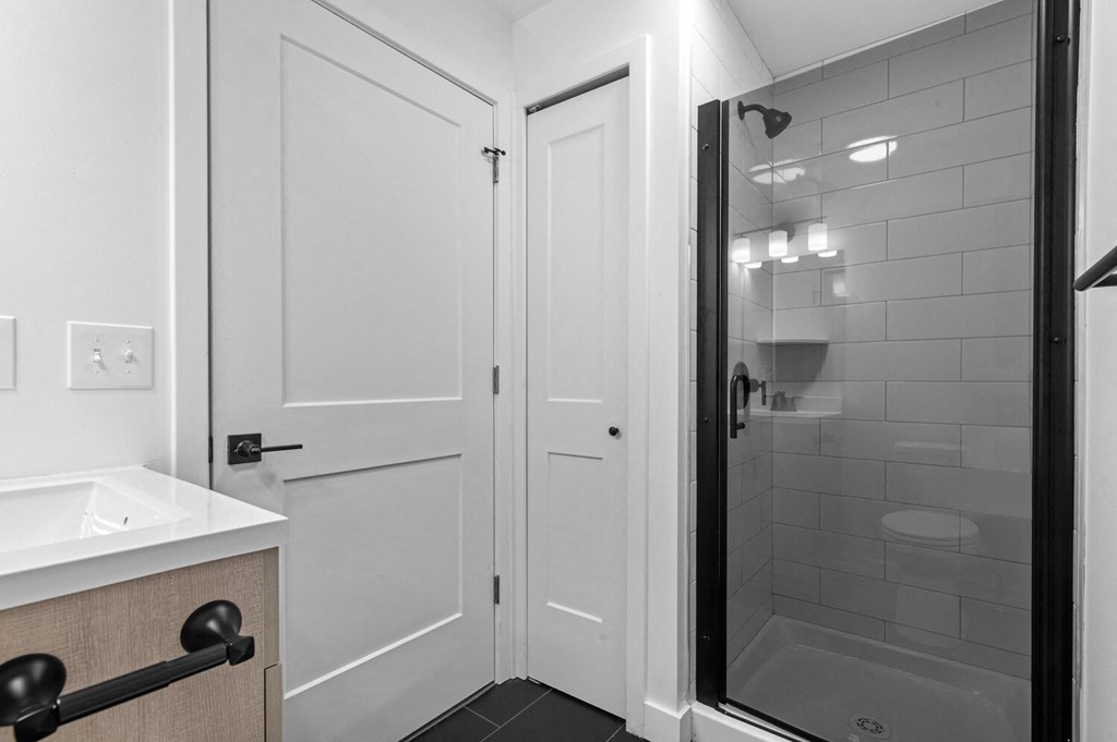 a bathroom with a shower and a sink and a mirror