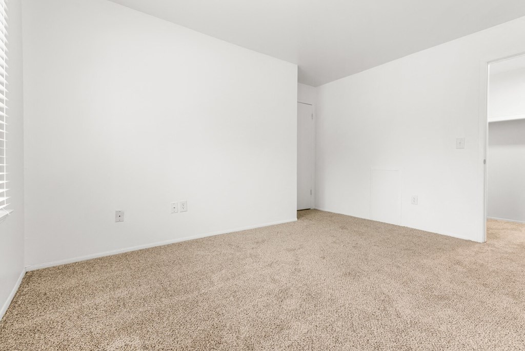 an empty room with carpet and white walls