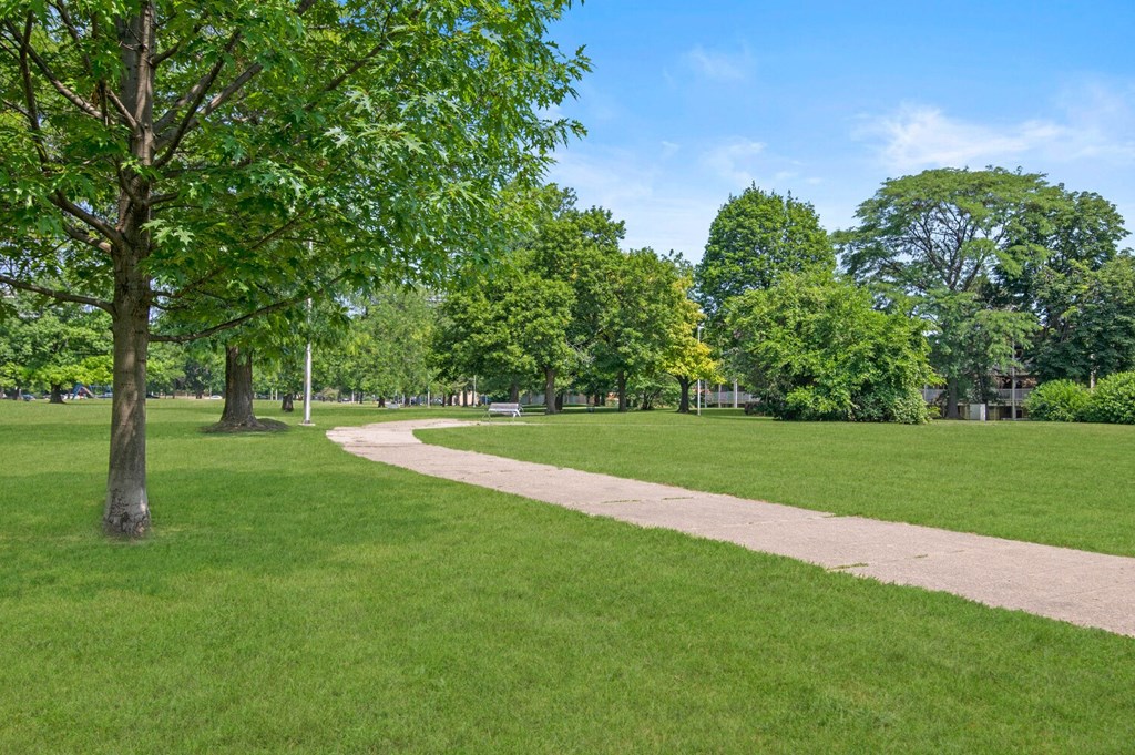 a path through a park with green grass and trees at Lafayette Park Place, Detroit, 48207