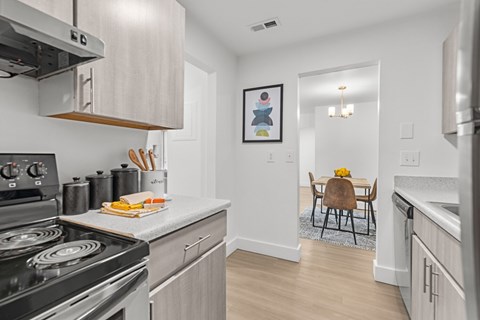 A modern kitchen with a stove, oven, and a dining table set for two.