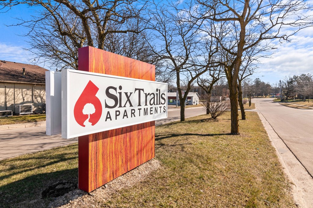 a sign for ski trails apartments on the side of a road