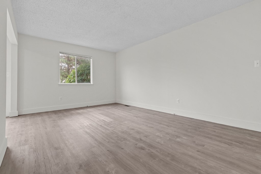 the spacious living room with hardwood floors and a window at Sterling Lake - Sterling Heights, MI, Michigan
