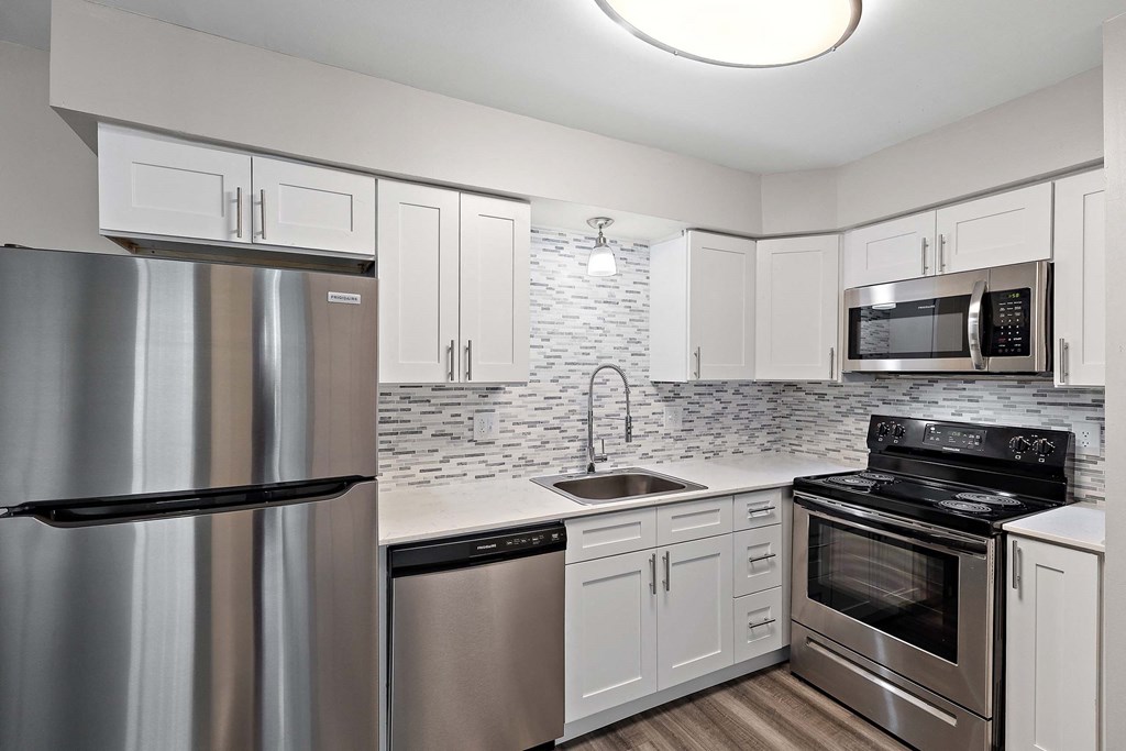 a kitchen with stainless steel appliances and white cabinets