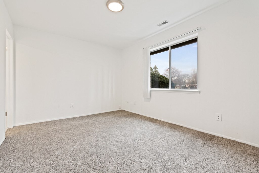 an empty room with carpet and a window