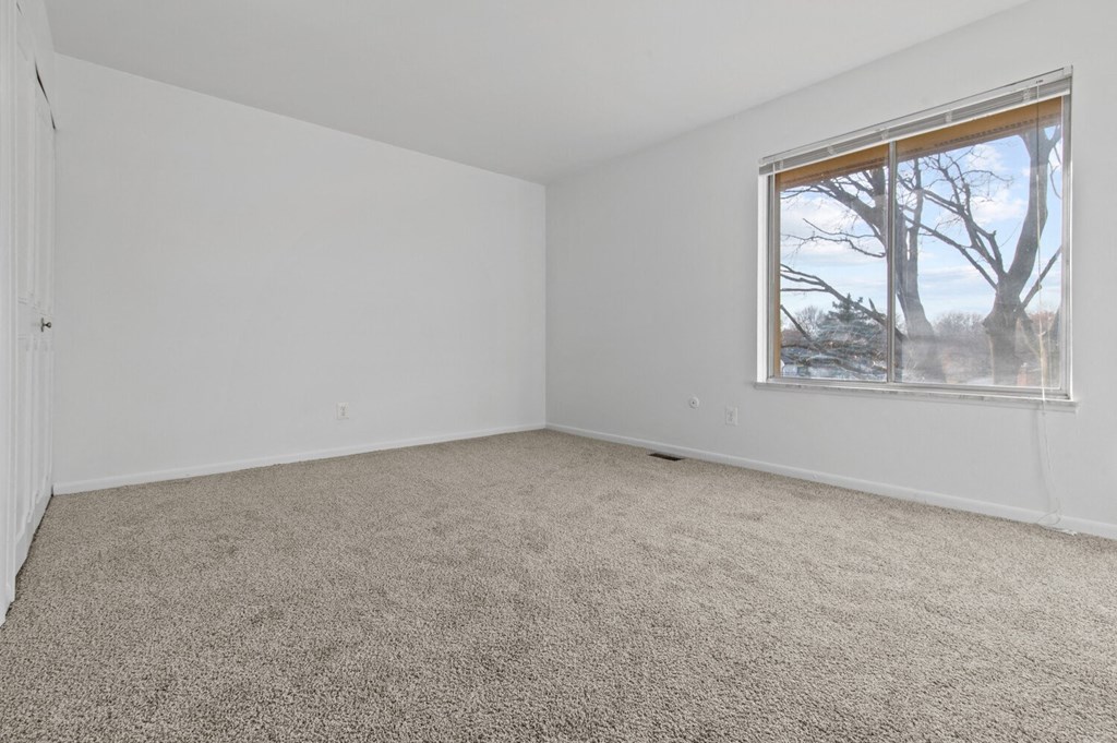 an empty room with carpet and a window