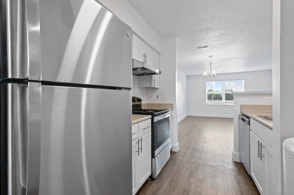 a kitchen with white cabinets and stainless steel appliances