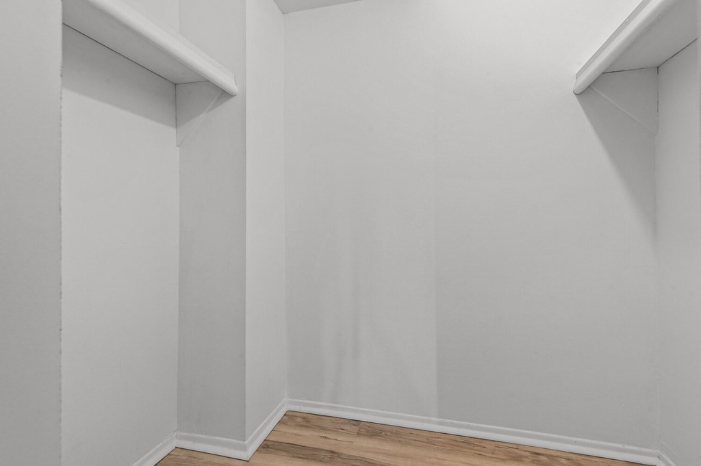 an empty room with white walls and a wooden floor