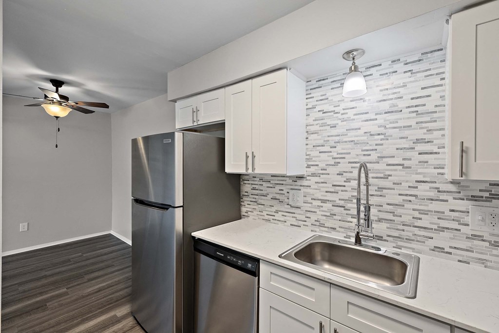 a kitchen with stainless steel appliances and white cabinets