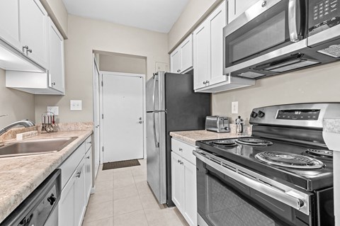 a kitchen with white cabinets and stainless steel appliances