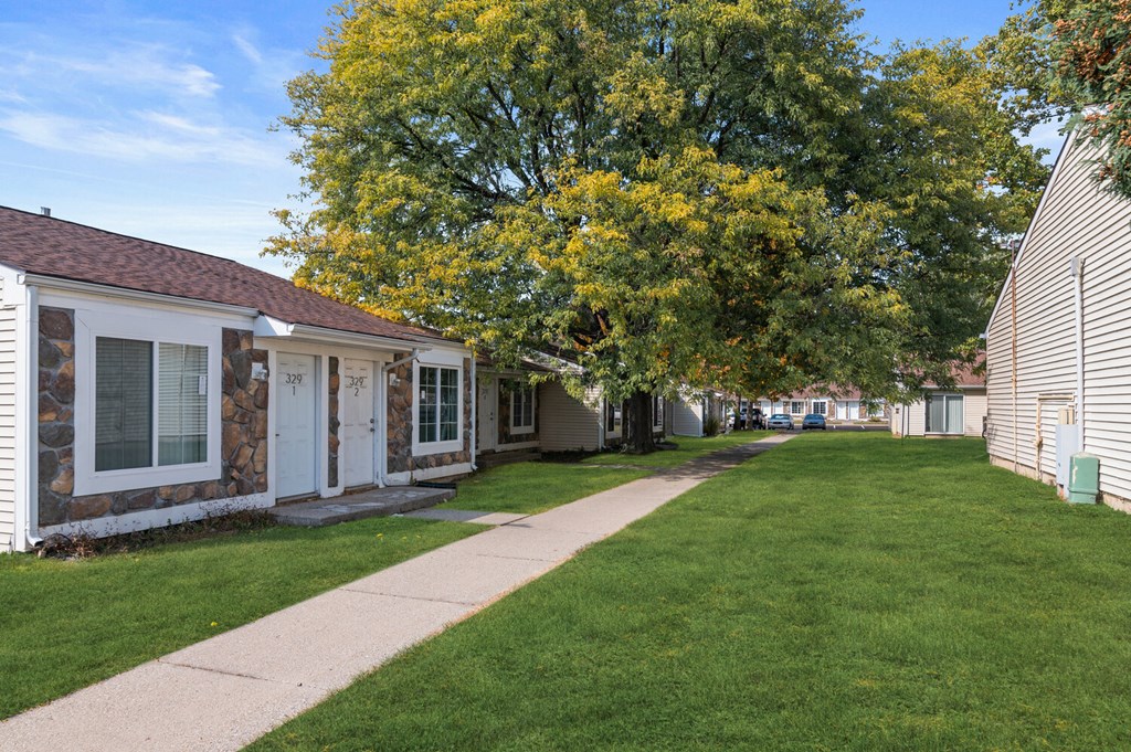 a sidewalk in front of a row of houses