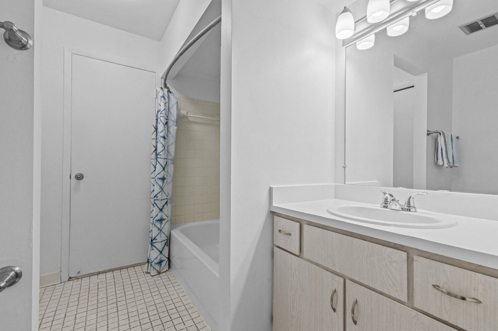a bathroom with a shower and a sink and a mirror at Edge At Farmington Hills - Farmington Hills, MI, Michigan
