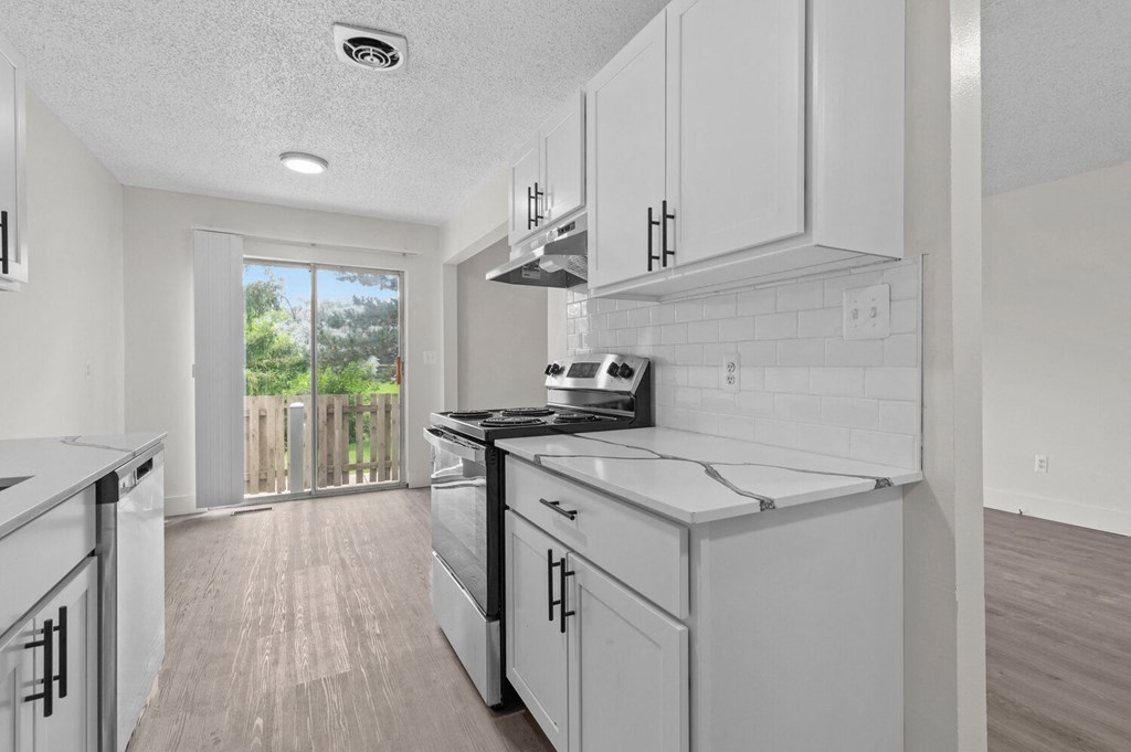 a white kitchen with white cabinets and white appliances at Sterling Lake - Sterling Heights, MI, Sterling Heights, 48312