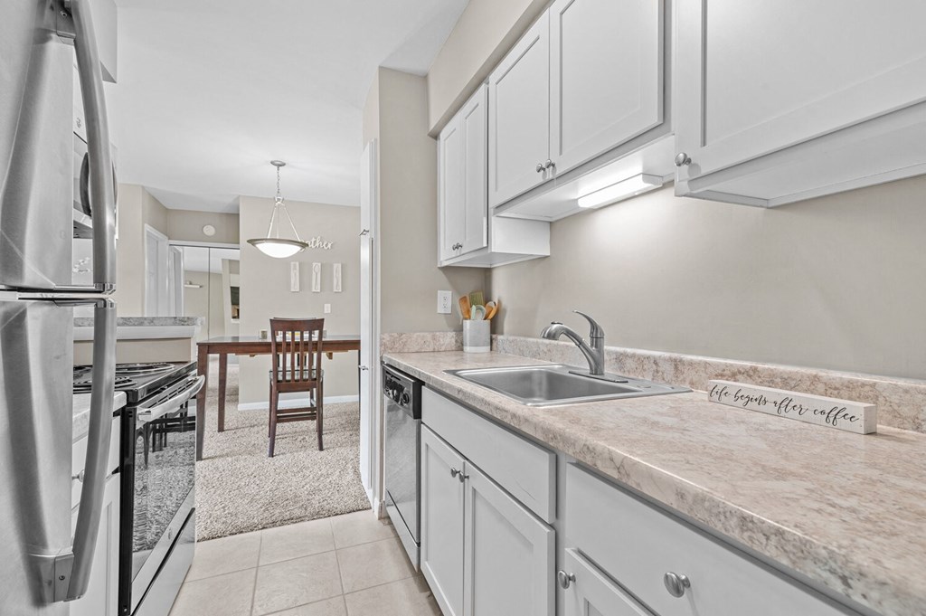 a kitchen with white cabinets and granite countertops at Apple Ridge Apartments - Livonia, MI, Michigan, 48152