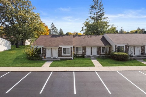 a white house with a lawn and a parking lot