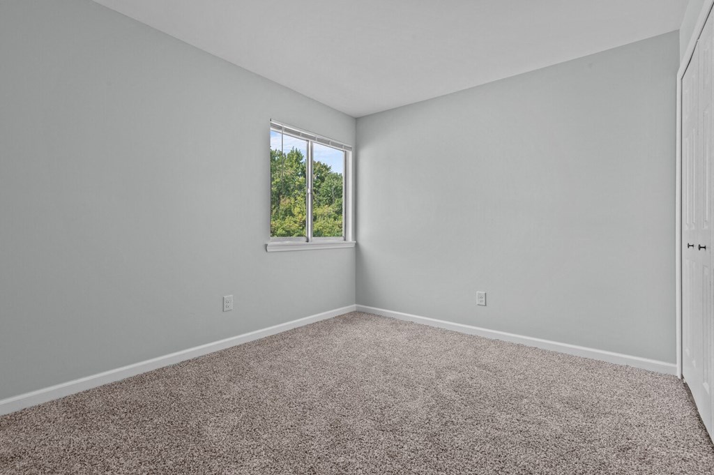 an empty room with carpet and a window