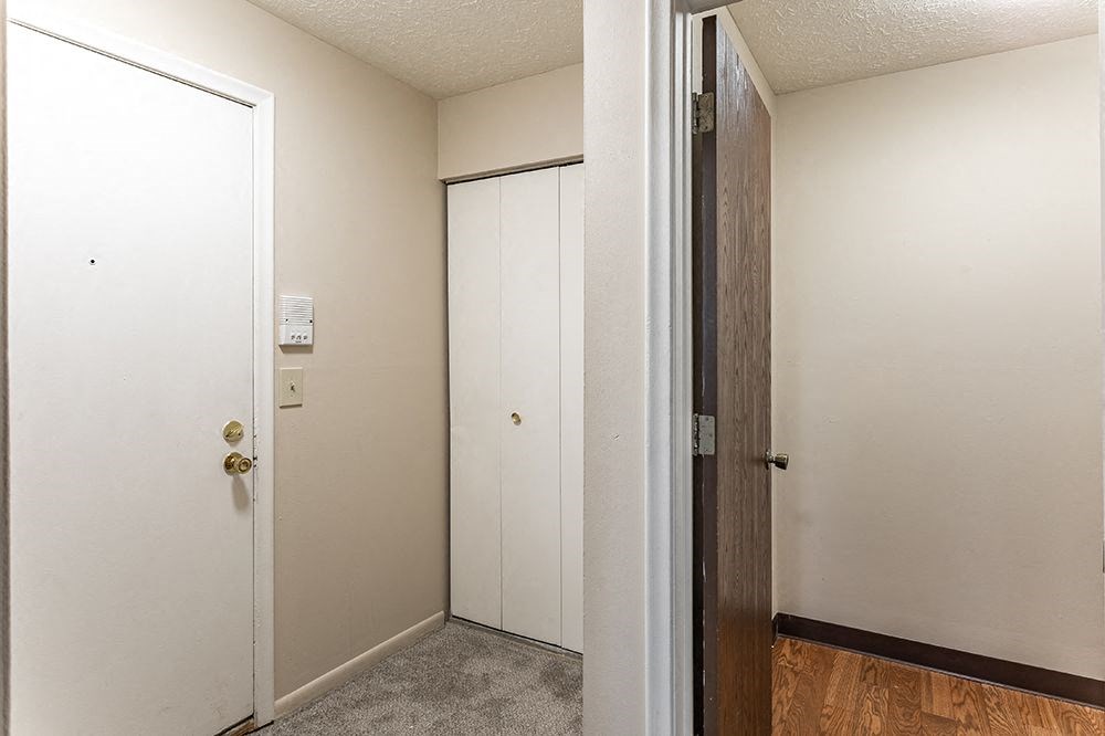 a bedroom with an open door and a door to a closet