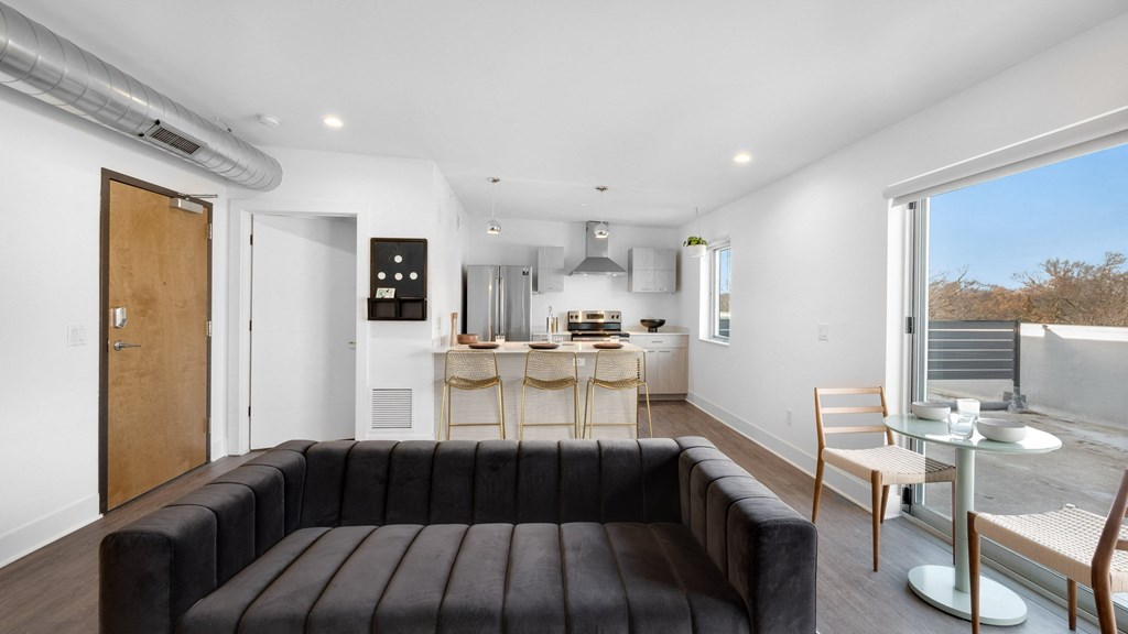 a living room with a couch and a kitchen in the background