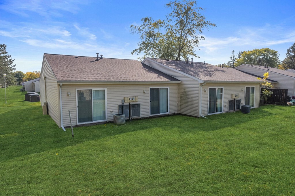 the back of a house with a grassy yard and a backyard