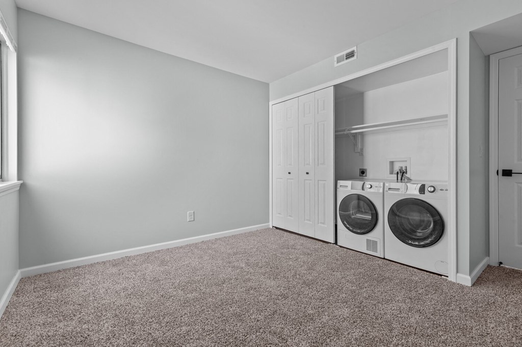 a washer and dryer in a laundry room with a door to the closet