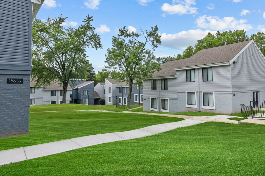 a grassy area with several houses in the background