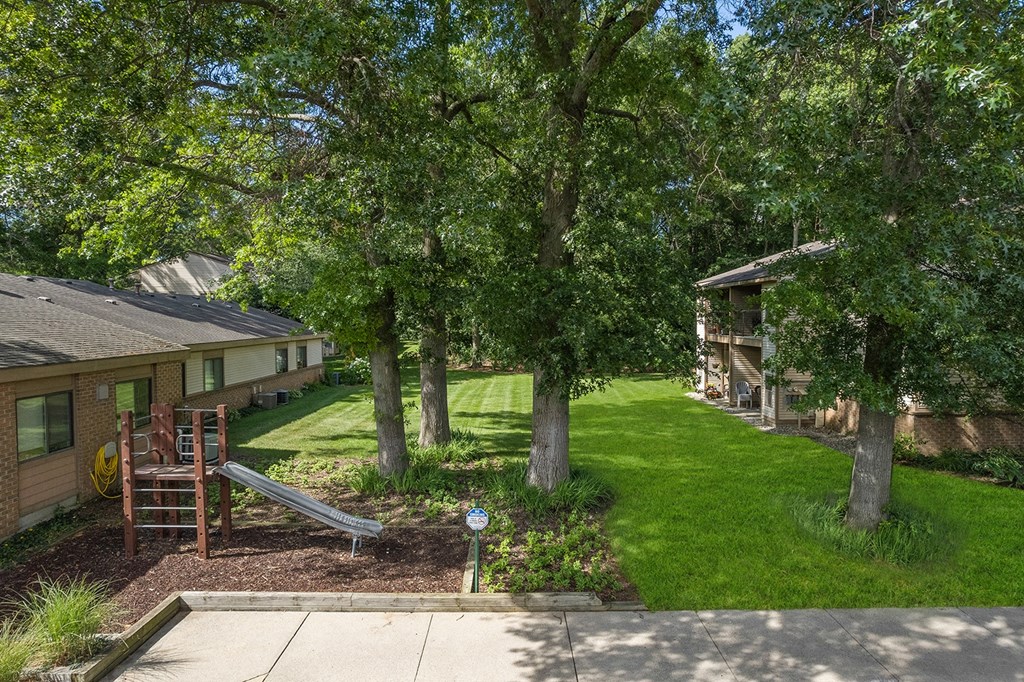 a view of a backyard with trees and a playground