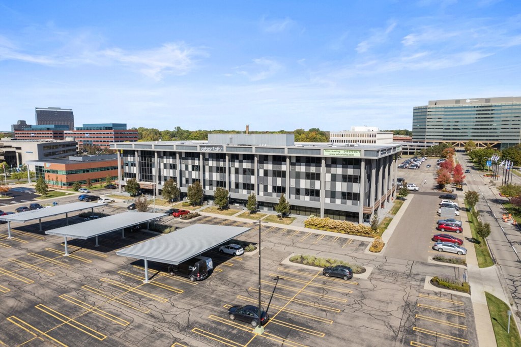 an aerial view of a parking lot in front of a large building