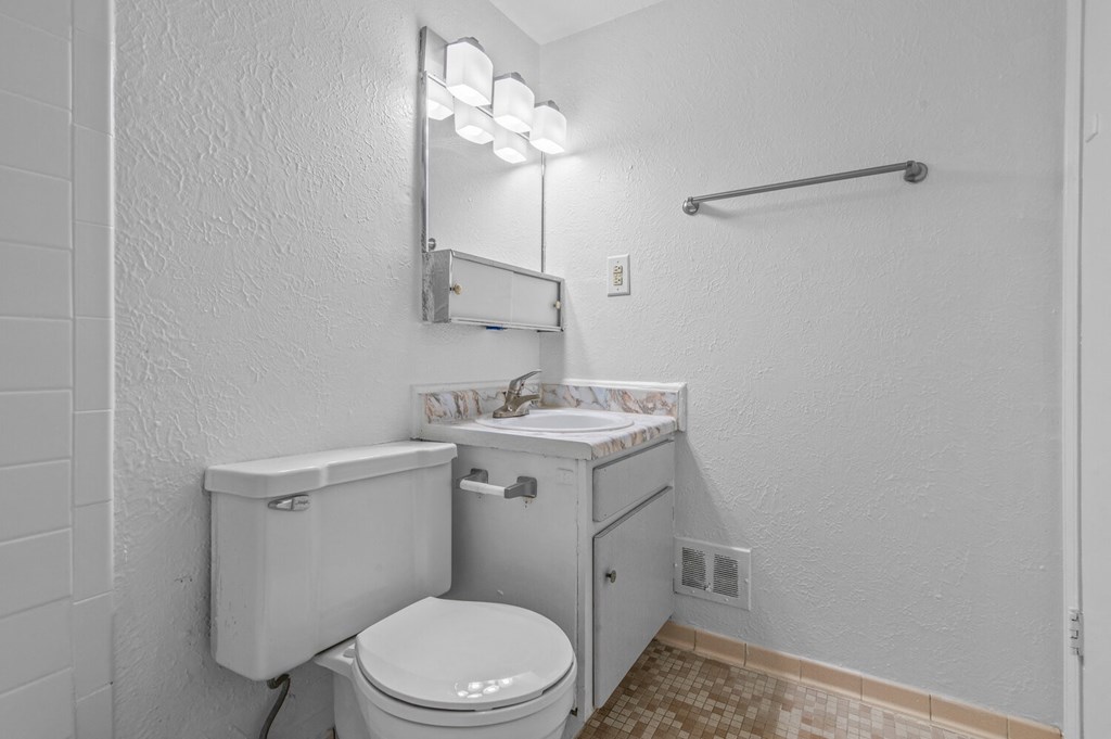 a bathroom with a toilet and a sink and a mirror