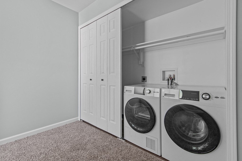 a washer and dryer in a laundry room with a white closet