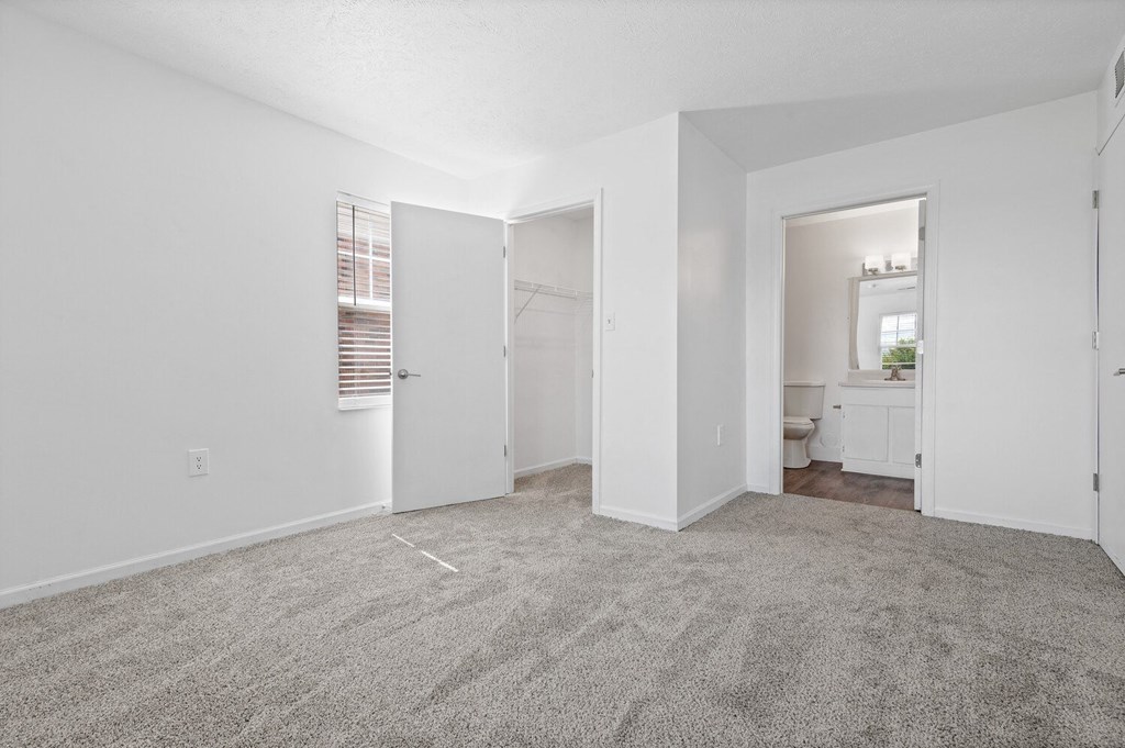 a bedroom with white walls and carpet